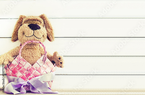 Stuffed Dog animal in a gift basket with a ribbon with copy space