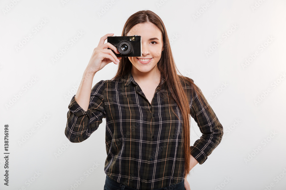 Smiling Woman in shirt making photo on retro camera Smiling Woman in shirt making photo on retro camera