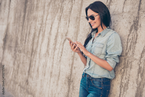 Portrait of pretty brunette read email on her smartphone and using 4g internet