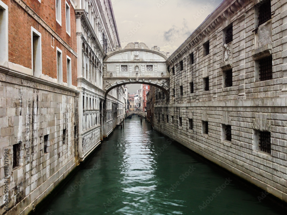 The bridge of Sighs in Venice sits over the calm water of a canal
