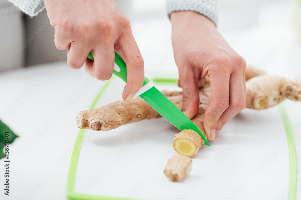 Woman cutting a fresh ginger root Woman cutting a fresh ginger root