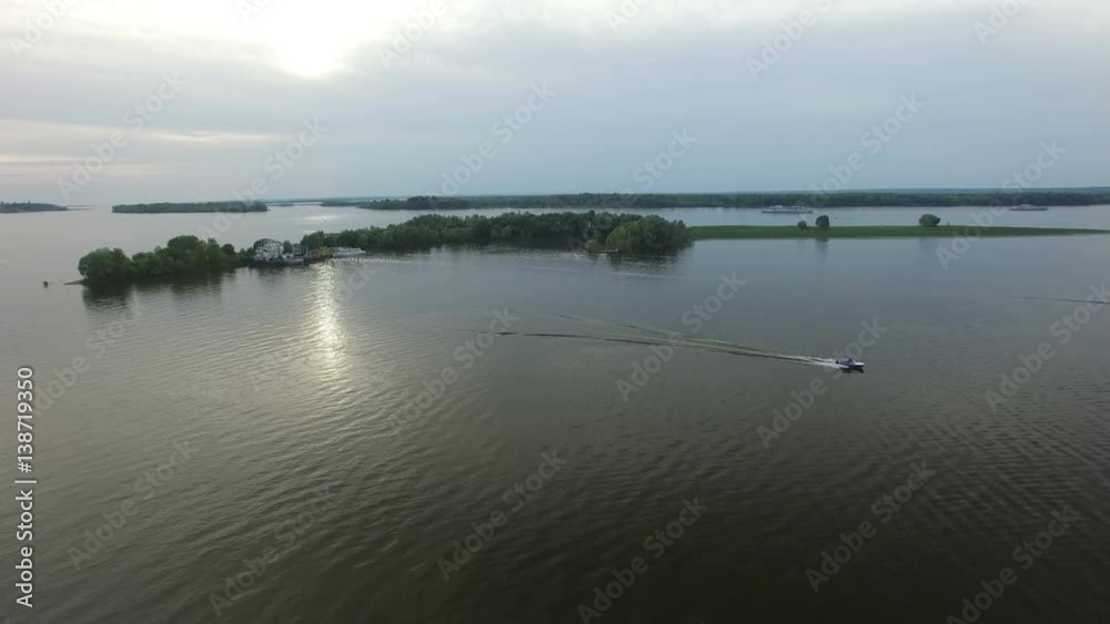 Speedboat Drifts on Wide River at Cloudy Sunset Speedboat Drifts on Wide River at Cloudy Sunset