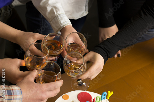 People drink at the table, clink glasses. Cheers!