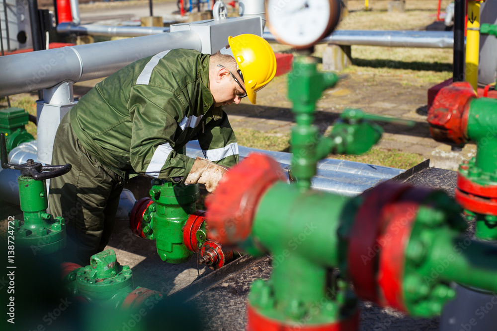 Oil worker repairing wellhead valve with the wrench