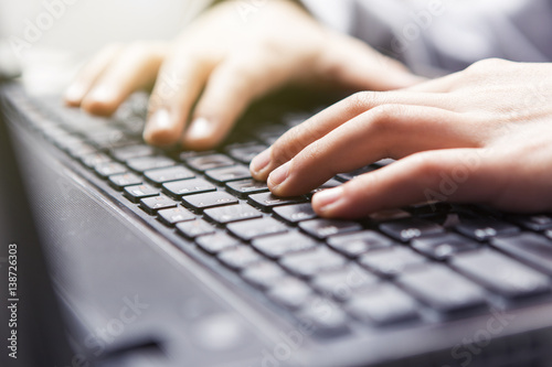 Technology, typing on a laptop keyboard (glare, flare)