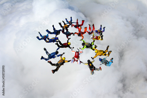 There is a group of skydivers above the clouds.