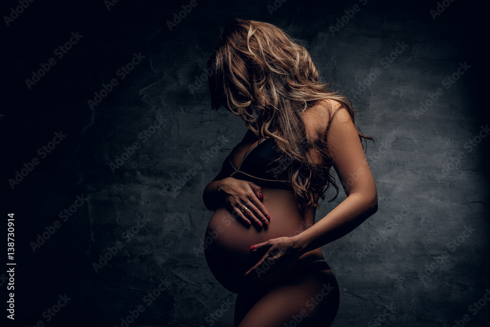 Portrait of pregnant female in a shadow.