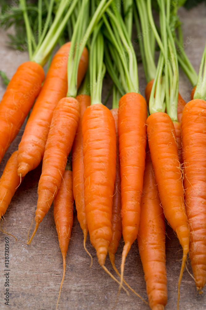 Fresh and sweet carrot on a grey wooden table.