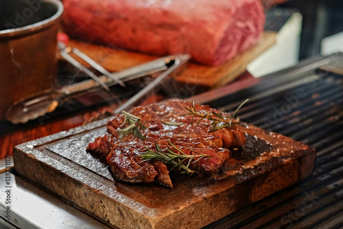 The grilled beef steak on a wooden board.