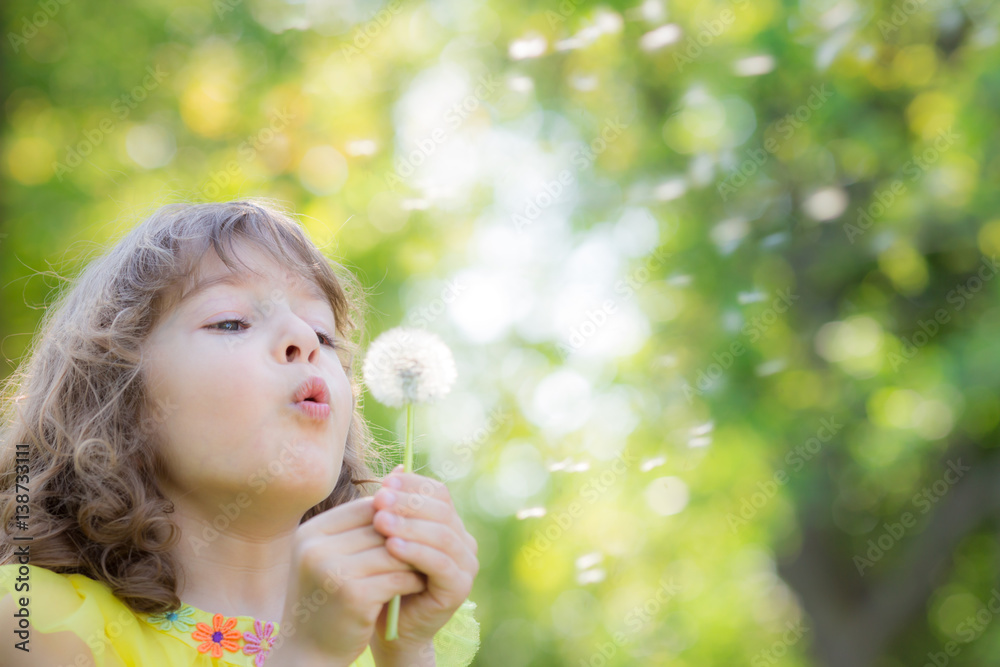 Happy child blowing dandelion flower outdoors Happy child blowing dandelion flower outdoors