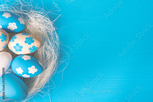 Easter eggs in nest on blue background