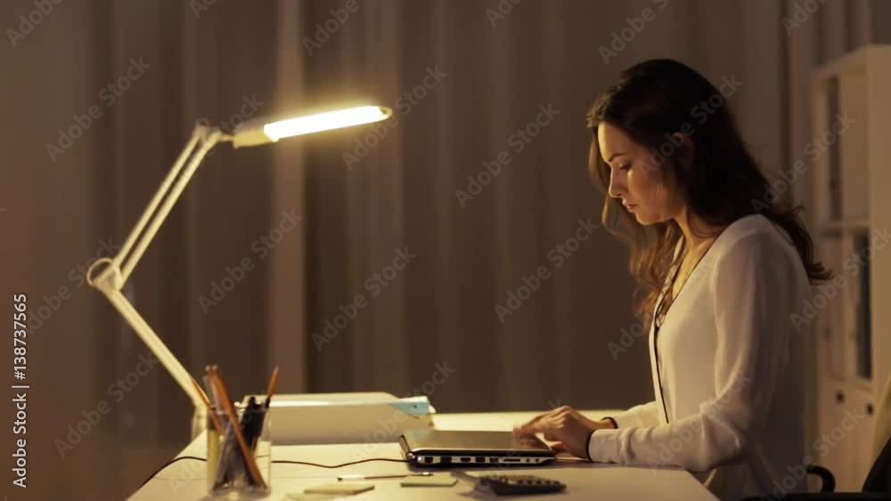 woman closing laptop and leaving night office woman closing laptop and leaving night office