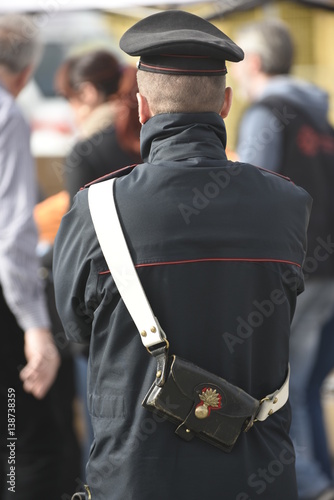 Carabiniere o poliziotto ,visto di spalle mentre osserva alcune perazioni. photo