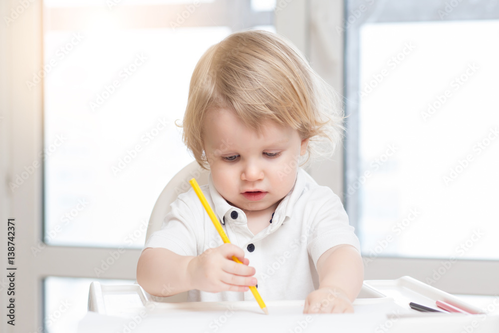 Schoolkid learns to write on sheet of paper, closeup Schoolkid learns to write on sheet of paper, closeup