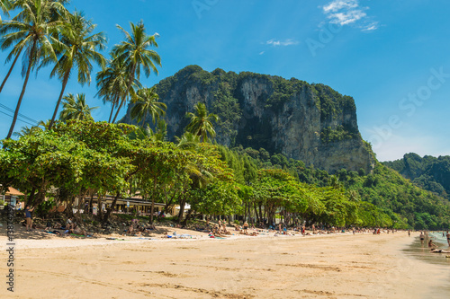 AO NANG, THAILAND, FEBRUARY 9, 2017: Tourists enjoying Ao Nang beach surrounded by awesome cliffs in Krabi province, Thailand photo