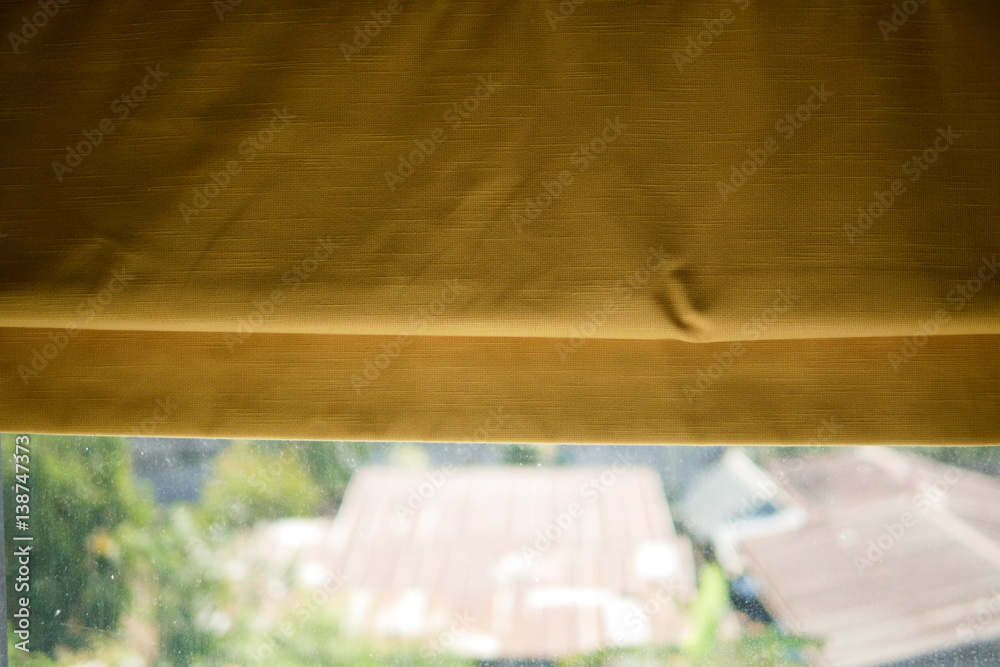 Yellow fabric curtain at a window Yellow fabric curtain at a window