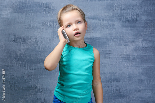 Cute little girl talking by...