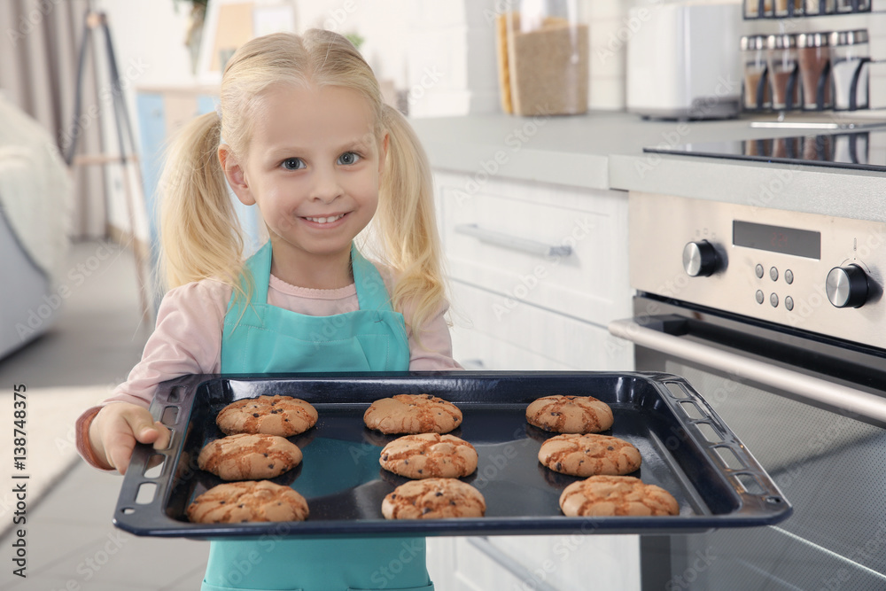Little girl holding biscuits on tray