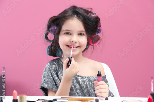 Cute little girl doing make...