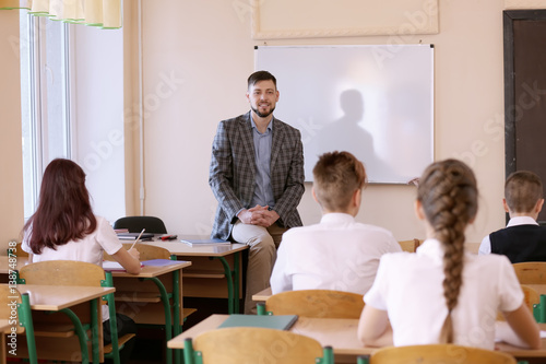 Pupils listening teacher in classroom