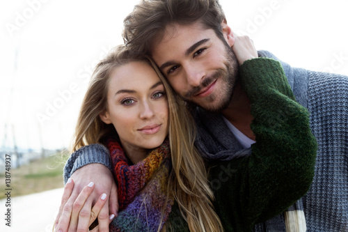 Beautiful young couple in love in a cold winter on the beach.