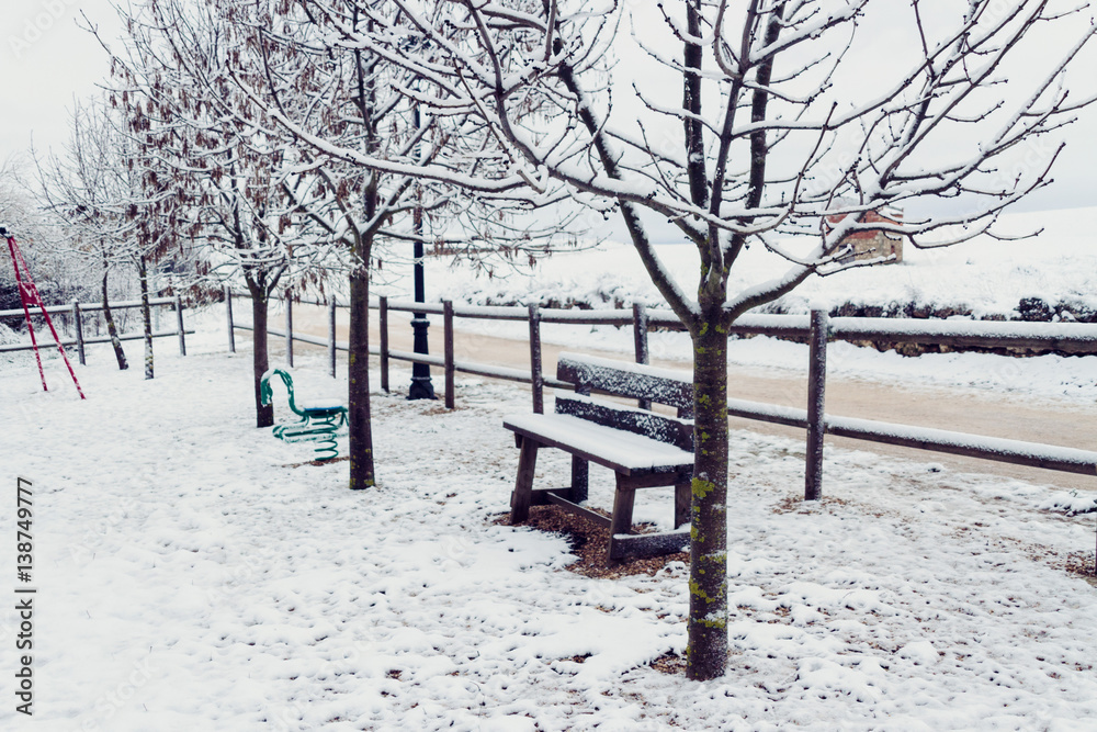 Parque en un pueblo totalmente cubierto de nieve en invierno 