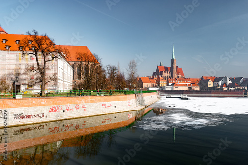 View on Church of the Holy Cross and St. Bartholomew, Odra river and Tumski Island, Wroclaw, Poland. Beautiful winter landscape.