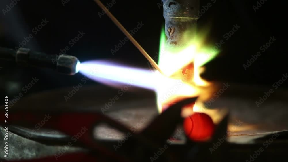 Workers grinding and welding copper pipes in a industrial factory