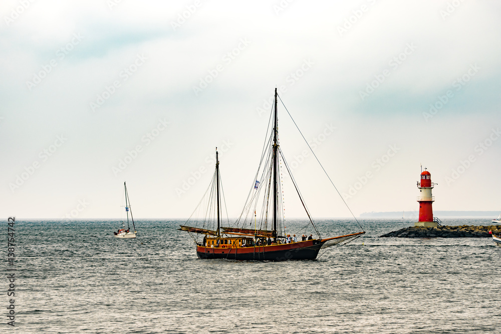 Fototapeta premium Sailing ship on the sea. Tall Ship and lighthouse Yachting travel.