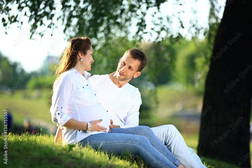 future parents sitting on the grass in the Park on a Sunny day. future parents sitting on the grass in the Park on a Sunny day.
