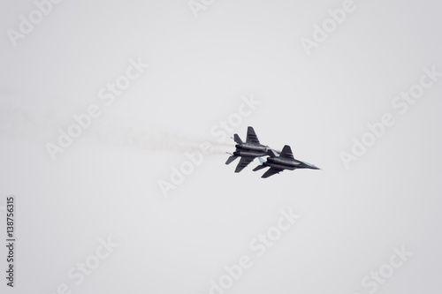 Fototapeta Naklejka Na Ścianę i Meble -  Air show in the sky above the Krasnodar airport flight school. Airshow in honor of Defender of the Fatherland. MiG-29 in the sky.