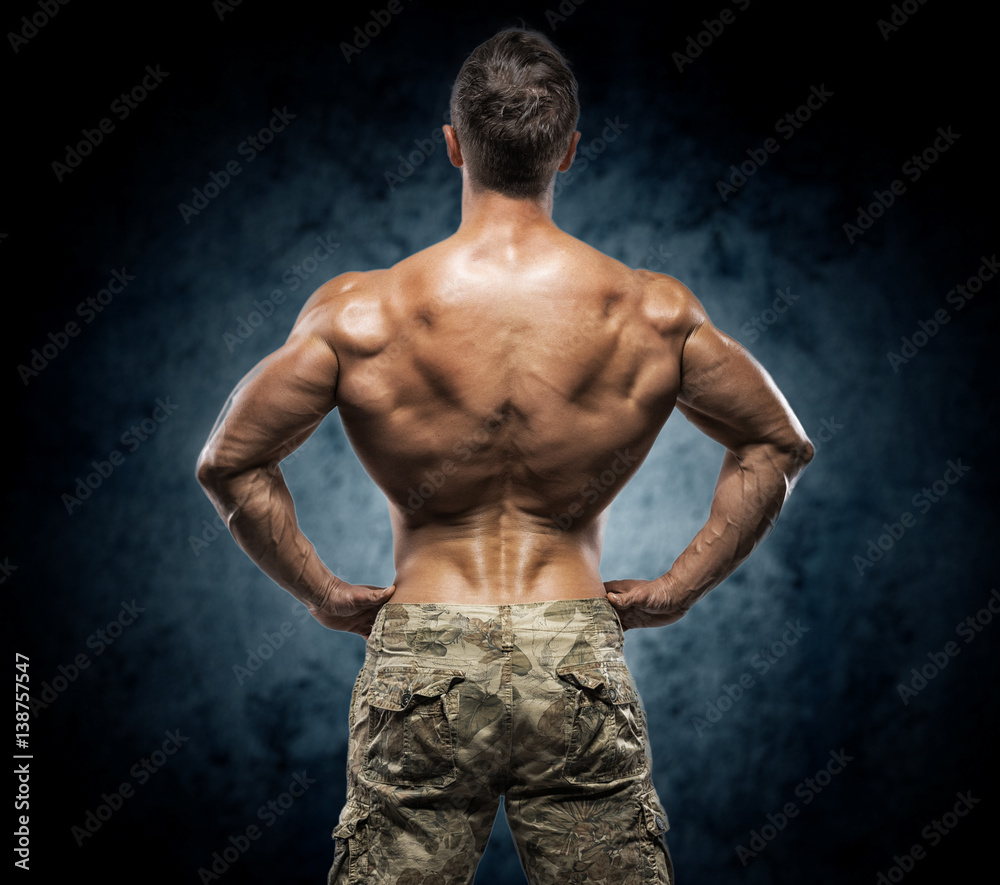 Fototapeta premium Muscular young man in studio on dark background