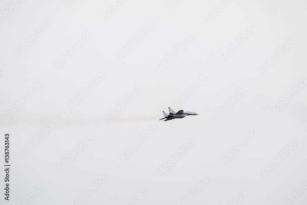 Fototapeta premium Air show in the sky above the Krasnodar airport flight school. Airshow in honor of Defender of the Fatherland. MiG-29 in the sky.