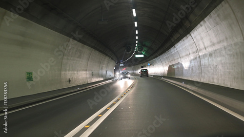 Light and projected shadows inside the Vedeggio-Cassarate road tunnel with lights signs and traffic