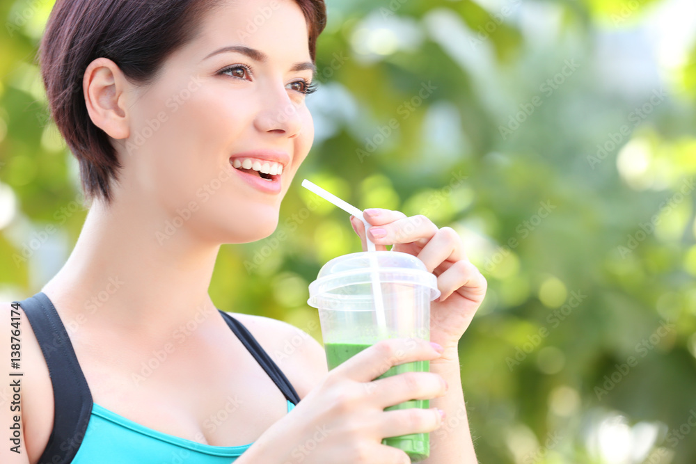 Young beautiful woman with green smoothie outdoor Young beautiful woman with green smoothie outdoor