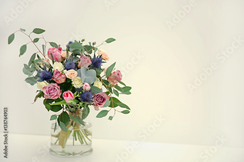 Glass vase with beautiful bouquet on light background