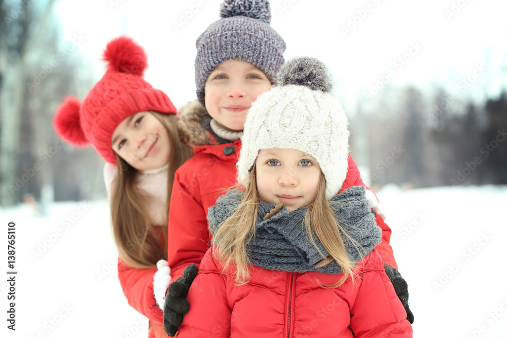 Happy children in red warm clothing having fun outdoors in winter