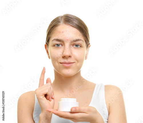 Beautiful young woman with cream for problem skin on white background