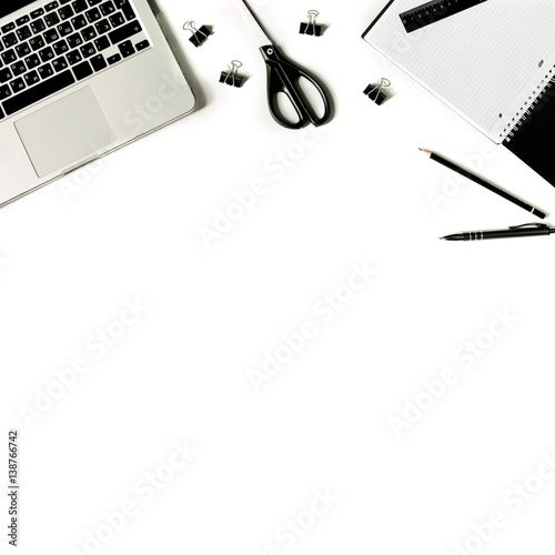 Square crop. White office desk frame with laptop keyboard and supplies. Laptop, notebook, pen, clips, pencil, scissors and office supplies on white background. Flat lay, top view, mockup