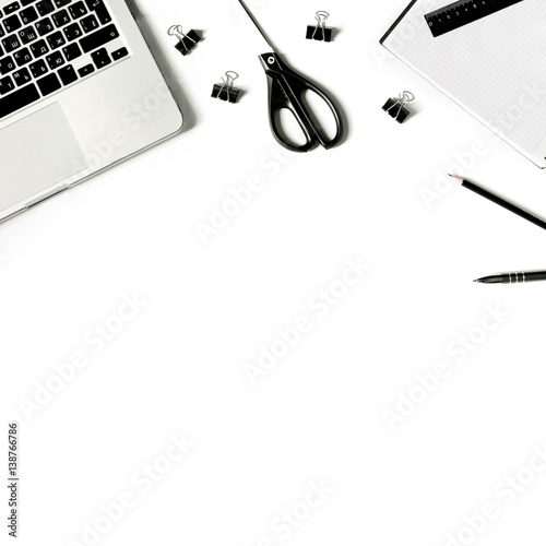 Square crop. White office desk with laptop keyboard and supplies. Laptop, notebook, pen, clips, pencil, scissors and office supplies on white background. Flat lay, top view, mockup