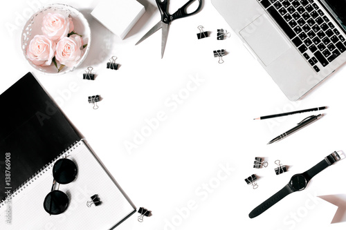 White office desk frame with laptop keyboard and supplies. Laptop, notebook, pen, roses, sunglasses, clips, pencil, scissors, watch and office supplies on white background. Flat lay, top view, mockup