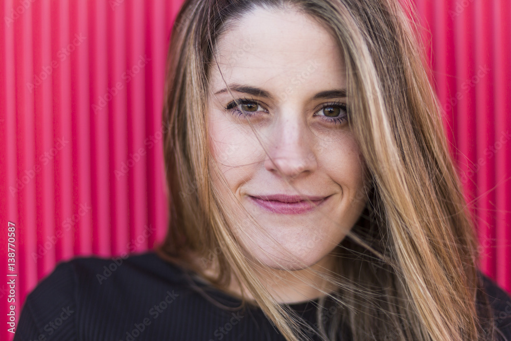 outdoors young woman close up portrait on red background with expressive eyes outdoors young woman close up portrait on red background with expressive eyes