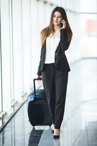 Portrait of an attractive young business woman walking with baggage before boarding on plane