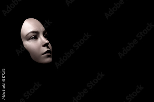 sad female face mask on black background with copy space