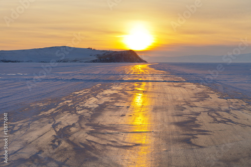 Baikal Lake. Ice road near Olkhon Island at sunset. Winter autotravel on the frozen lake photo