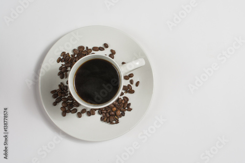 Above view of coffee cup on saucer with coffee beans