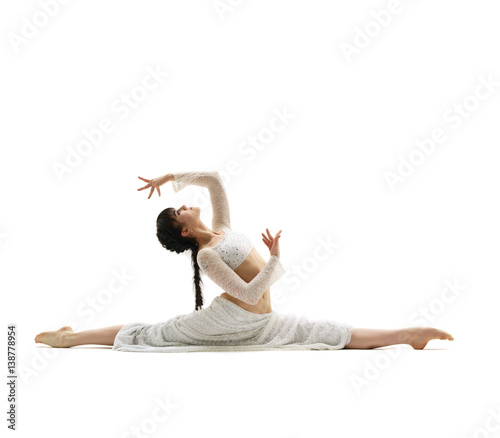 Young gymnast sitting in graceful split in studio