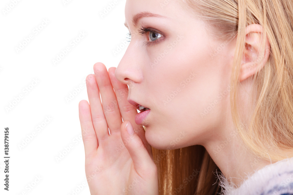 Young blonde woman whispering with hand near mouth Young blonde woman whispering with hand near mouth