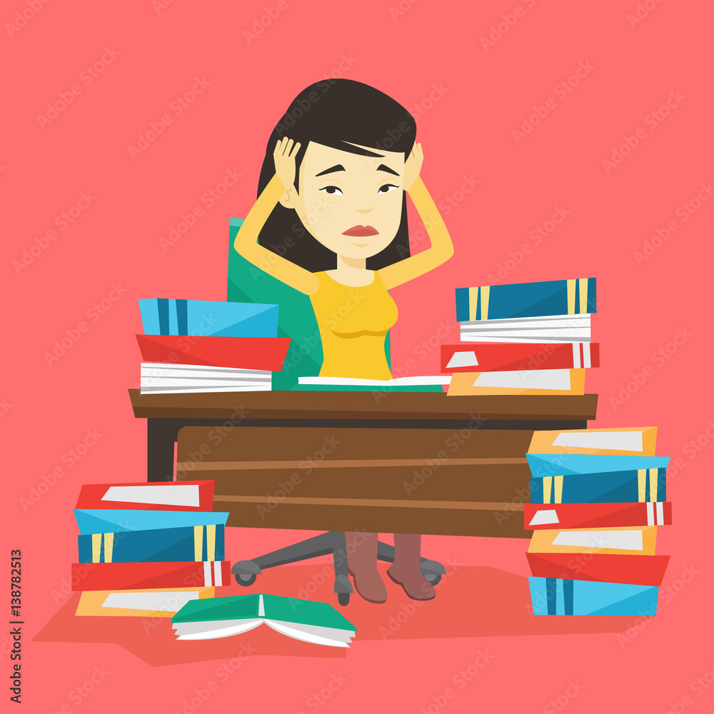 Student sitting at the table with piles of books.