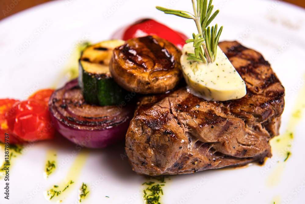 thick steak with rosemary and fried vegetables cheese on white plate. close up thick steak with rosemary and fried vegetables cheese on white plate. close up